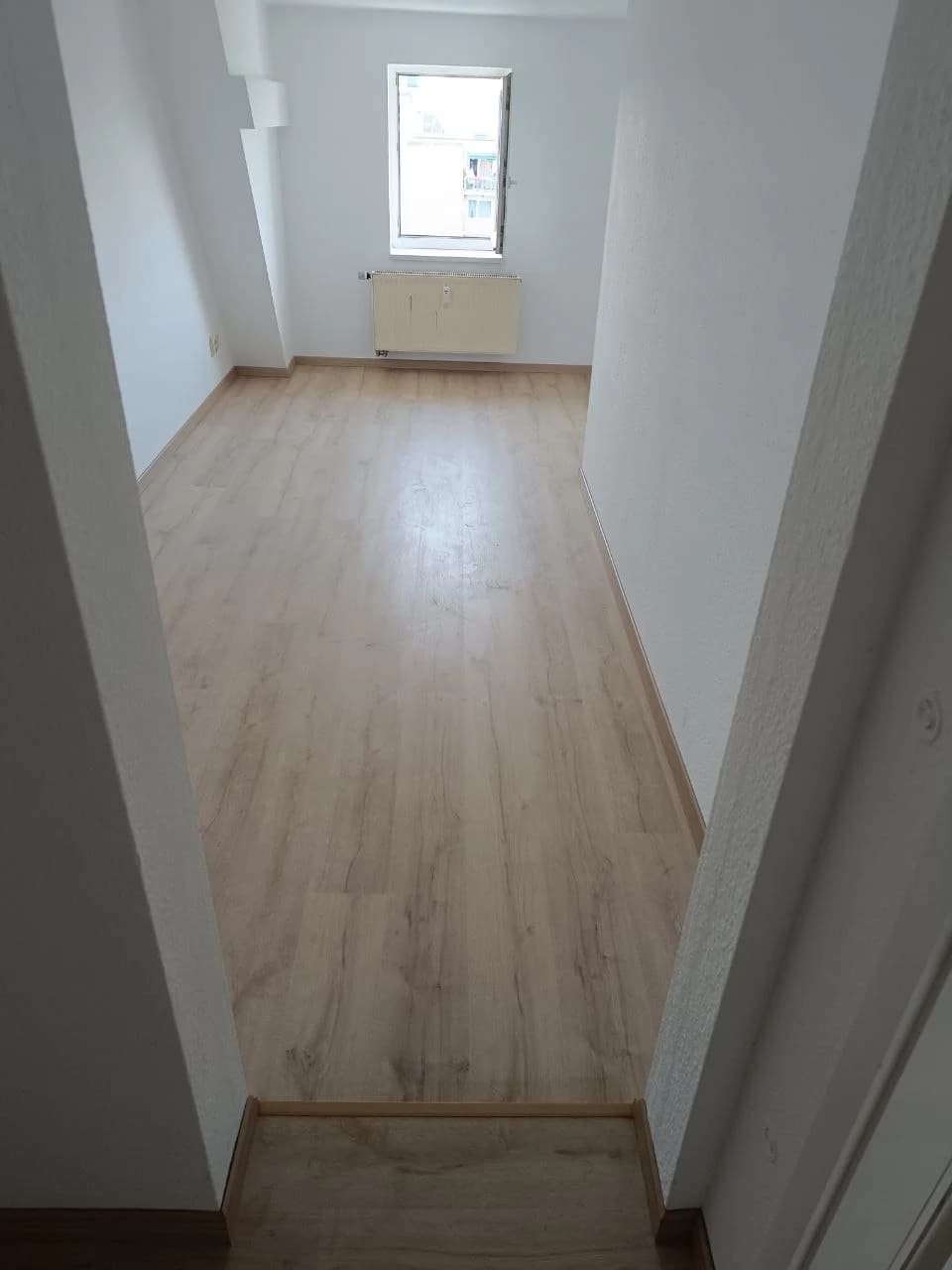Renoviertes Zimmer in Halle (Saale) mit hellem Laminat und weißen Wänden