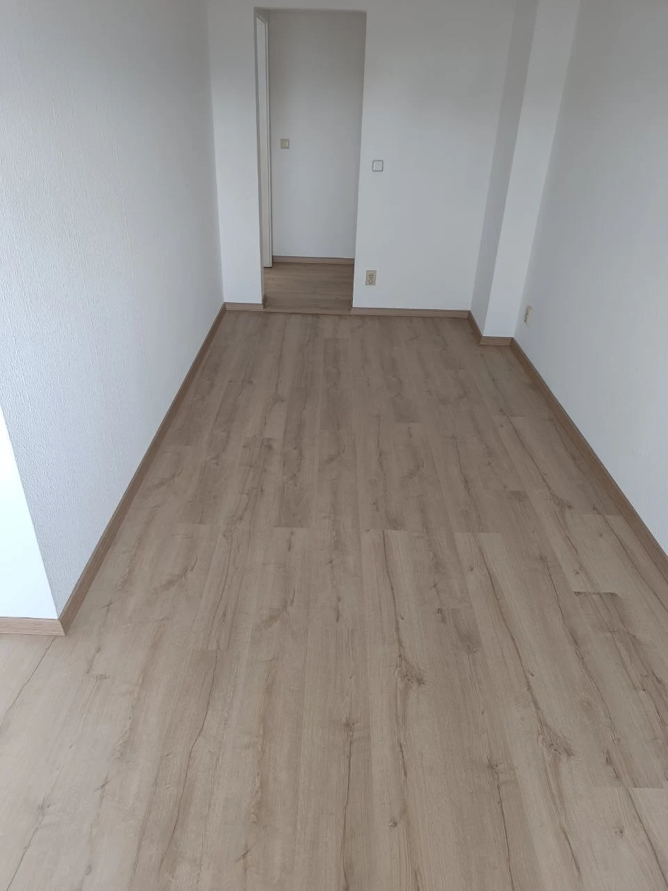 Laminat, Sockelleisten und Übergang zwischen zwei renovierten Räumen