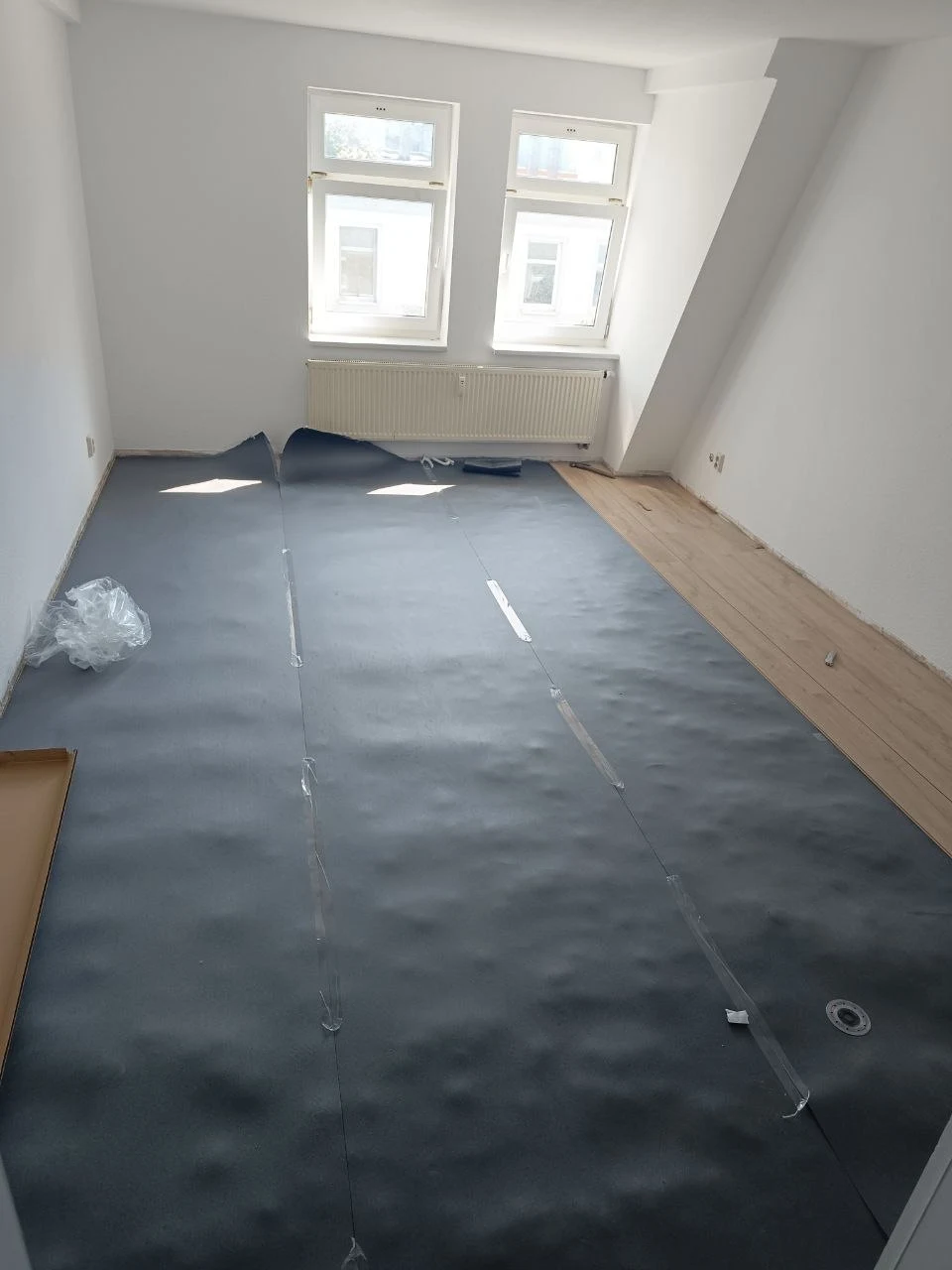 Laminatverlegung mit sichtbarer Unterlage in einem Zimmer der Wohnung
